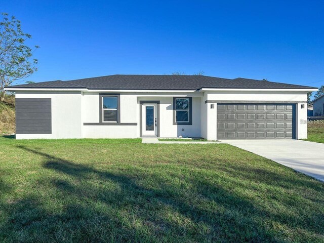 single story home with a garage and a front lawn