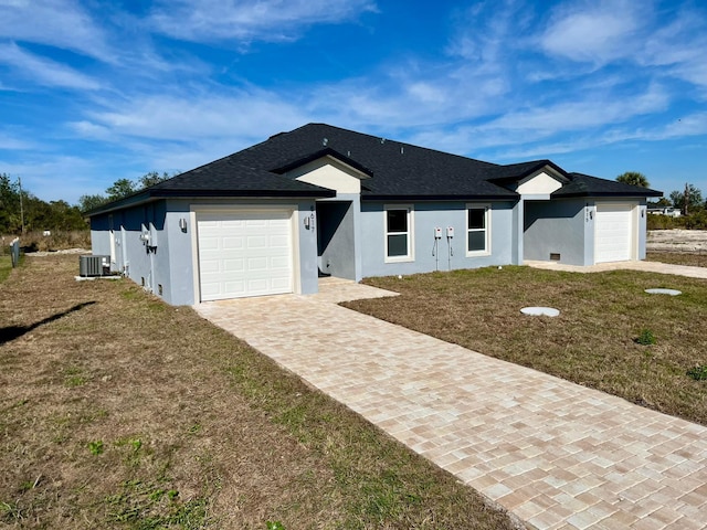 ranch-style home featuring central AC, a garage, and a front lawn