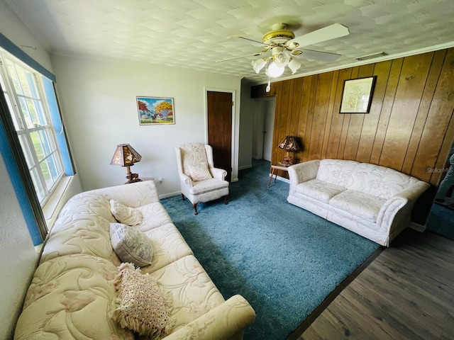 living room featuring wood walls, ceiling fan, and dark hardwood / wood-style floors