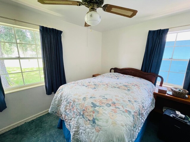 bedroom featuring dark colored carpet and ceiling fan