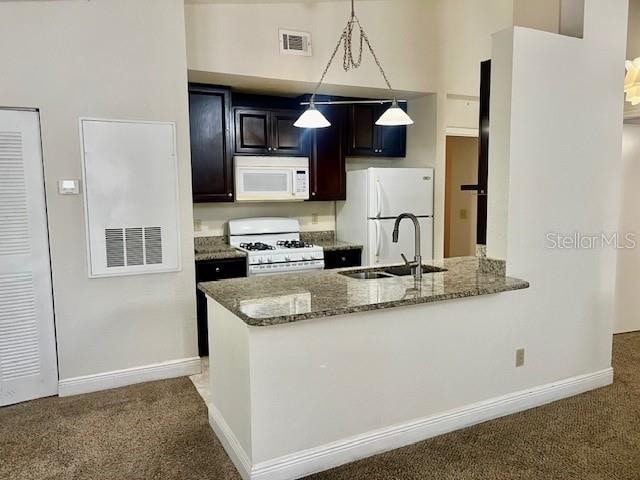 kitchen with white appliances, carpet, kitchen peninsula, and sink