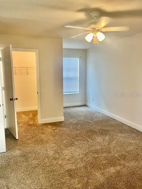 carpeted spare room with ceiling fan