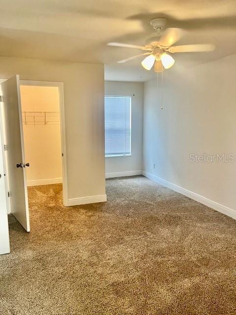 spare room featuring carpet floors and ceiling fan