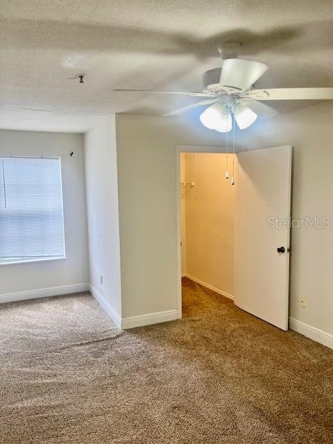 carpeted empty room featuring ceiling fan