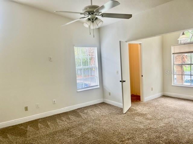 unfurnished bedroom with carpet, ceiling fan, and multiple windows