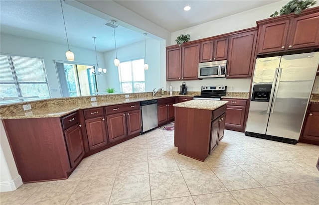 kitchen featuring kitchen peninsula, stainless steel appliances, a notable chandelier, a kitchen island, and hanging light fixtures