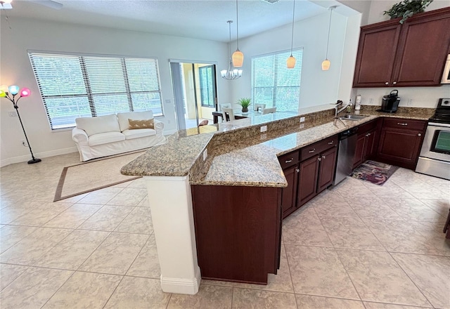 kitchen with kitchen peninsula, sink, pendant lighting, and appliances with stainless steel finishes