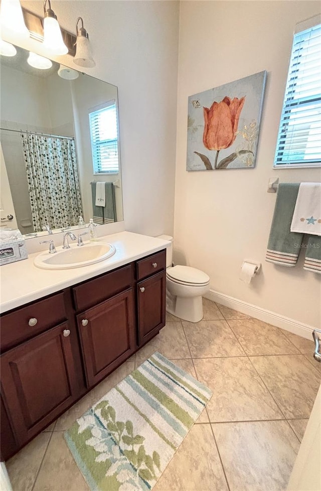 bathroom with a wealth of natural light, tile patterned flooring, and toilet