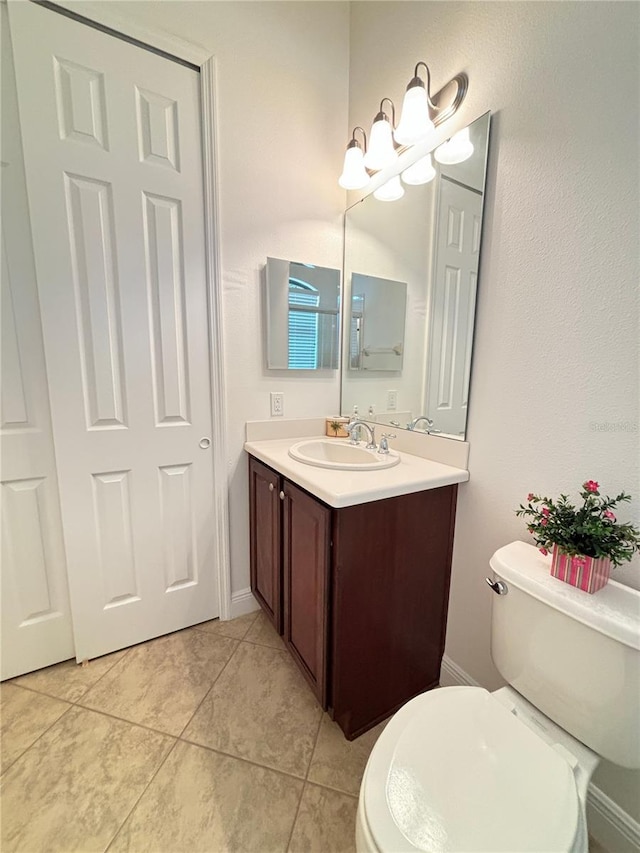 bathroom featuring tile patterned floors, vanity, and toilet