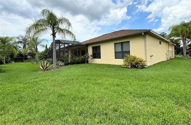 back of house with a yard and a lanai