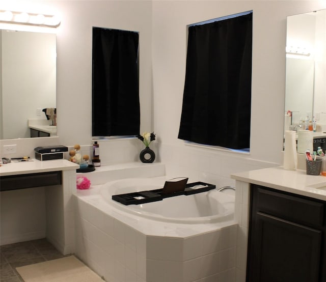 bathroom with tile patterned floors, vanity, and a relaxing tiled tub