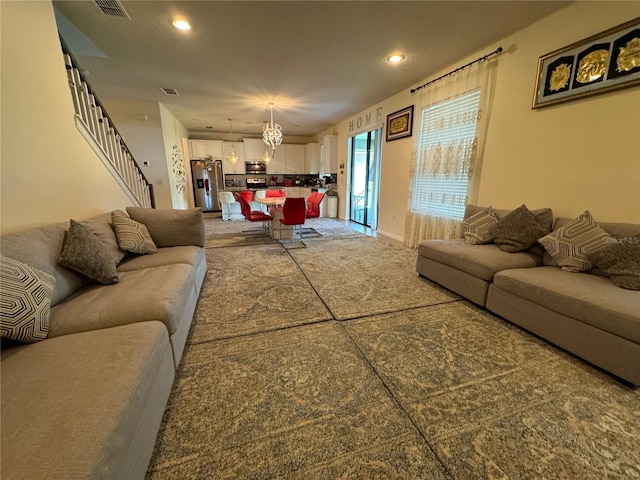 carpeted living room featuring a notable chandelier