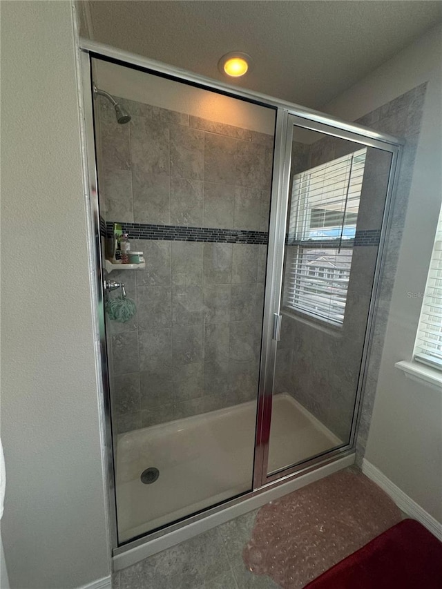 bathroom featuring tile patterned floors and a shower with shower door