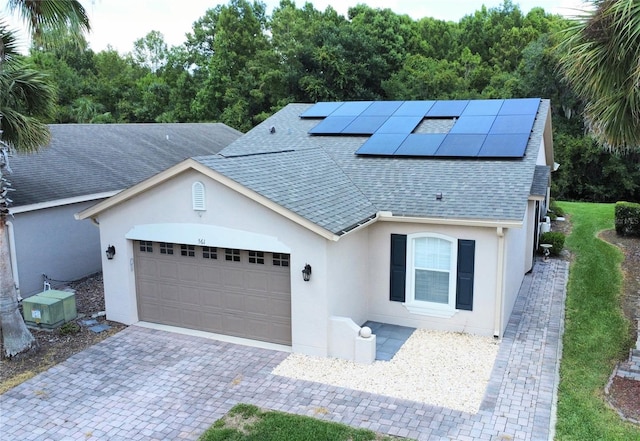 view of front of home featuring solar panels, a garage, and central AC