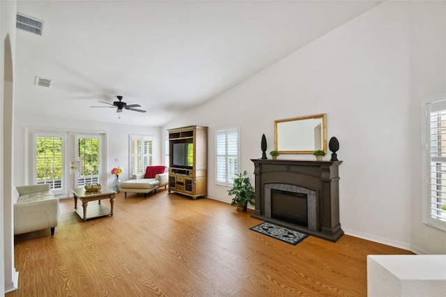 living room featuring light wood-type flooring, plenty of natural light, lofted ceiling, and ceiling fan