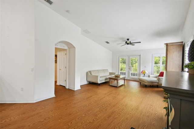 unfurnished living room with ceiling fan, french doors, and light wood-type flooring