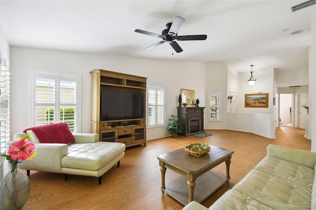 living room with ceiling fan, wood-type flooring, and vaulted ceiling