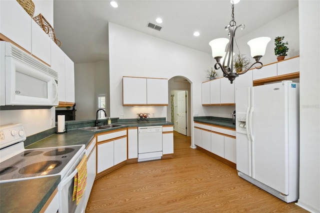 kitchen featuring white cabinetry, sink, hanging light fixtures, a chandelier, and white appliances