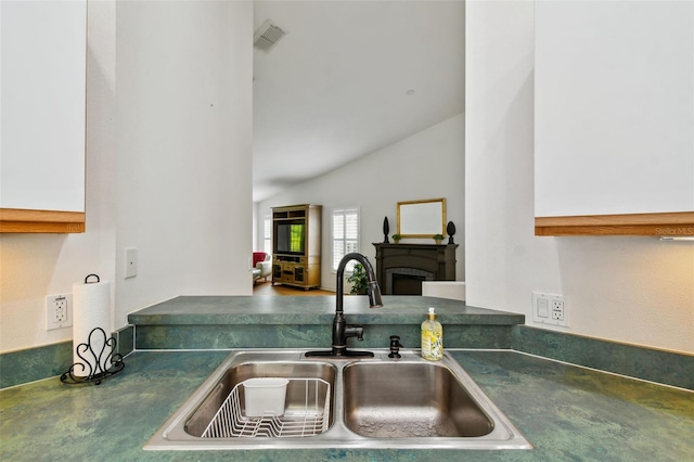 kitchen featuring lofted ceiling and sink