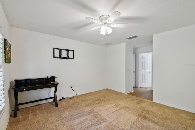 spare room featuring ceiling fan and carpet floors