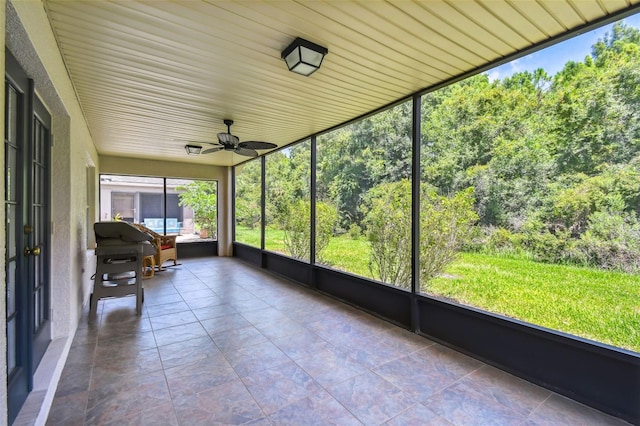 unfurnished sunroom featuring ceiling fan