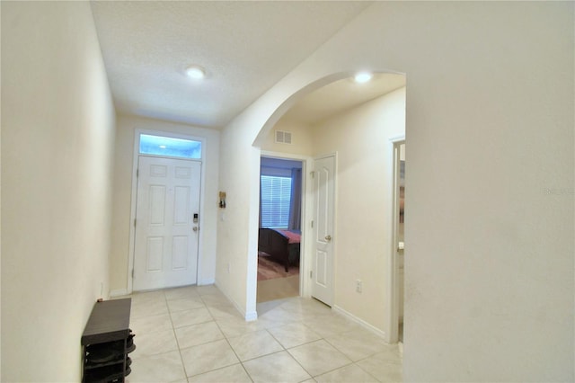 foyer featuring a textured ceiling and light tile patterned flooring