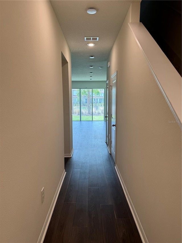 corridor with dark hardwood / wood-style flooring