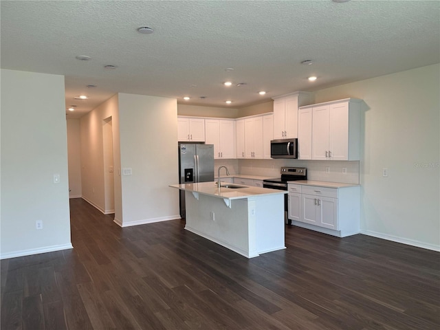 kitchen with a kitchen island with sink, sink, stainless steel appliances, and white cabinets