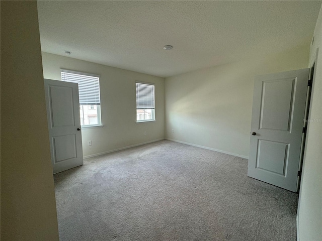 carpeted spare room with a textured ceiling