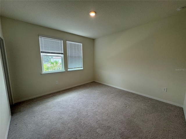 carpeted empty room with a textured ceiling