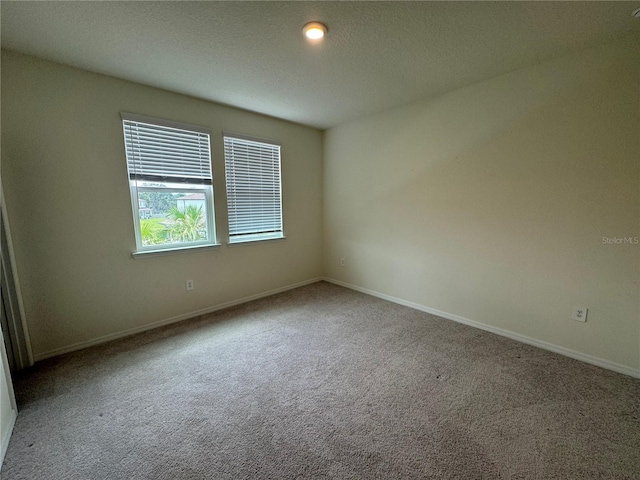 carpeted empty room featuring a textured ceiling