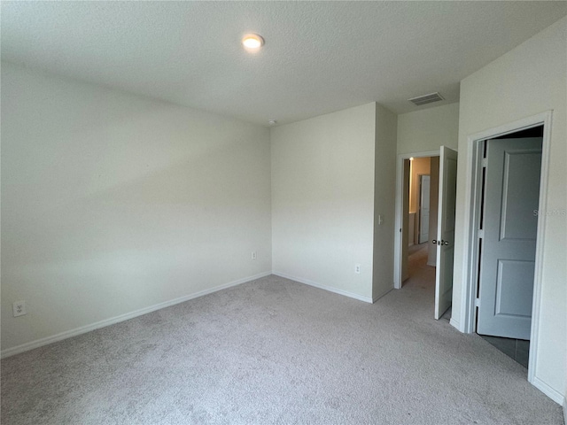 carpeted empty room featuring a textured ceiling