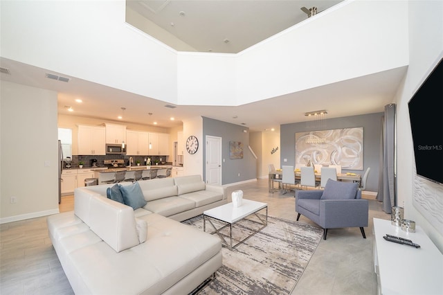 tiled living room featuring a towering ceiling