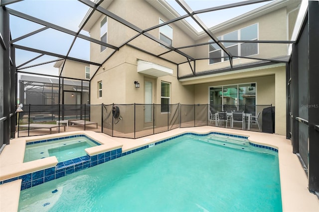 view of swimming pool with an in ground hot tub, a patio area, and glass enclosure