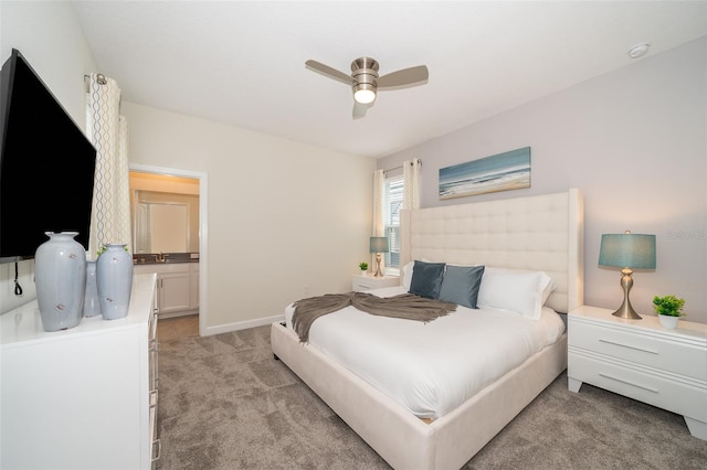 carpeted bedroom featuring ensuite bath and ceiling fan