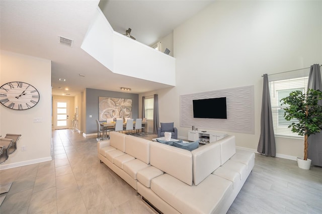 living room with a towering ceiling and light tile patterned floors