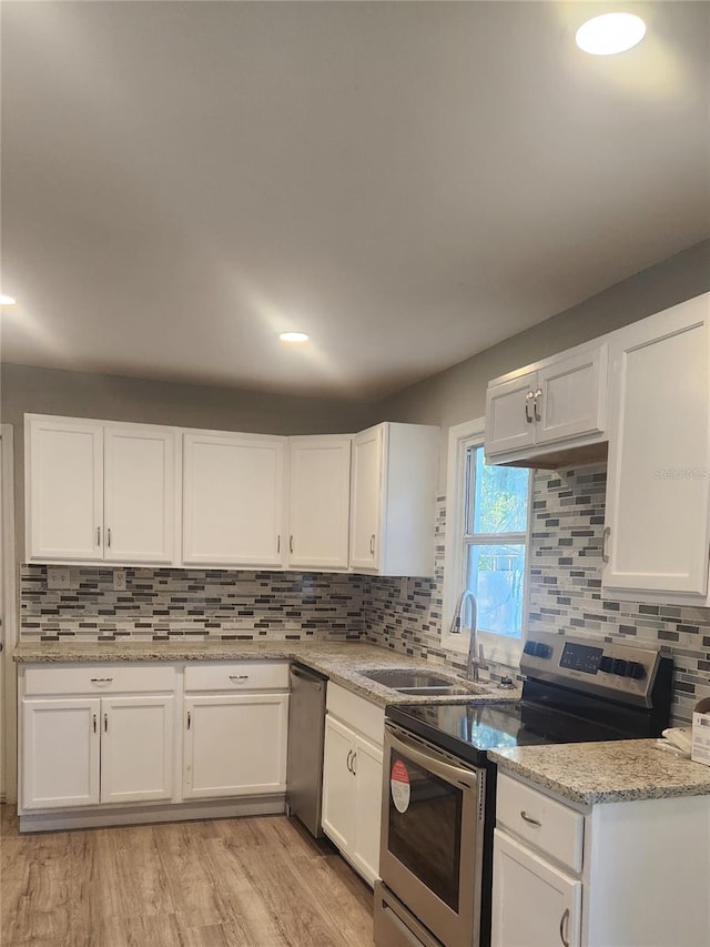 kitchen featuring white cabinets, appliances with stainless steel finishes, and light wood-type flooring