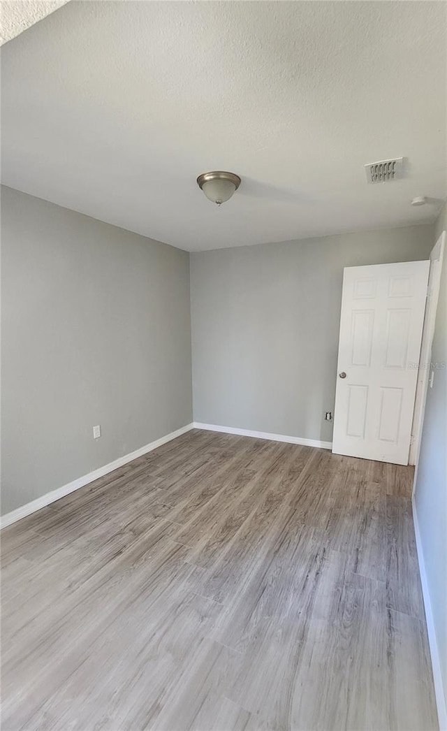 unfurnished room featuring a textured ceiling and hardwood / wood-style flooring