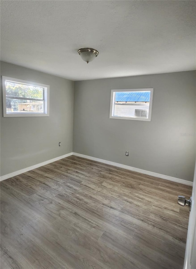 empty room featuring a healthy amount of sunlight and hardwood / wood-style flooring