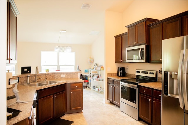 kitchen with stainless steel appliances, sink, kitchen peninsula, light stone counters, and light tile patterned floors