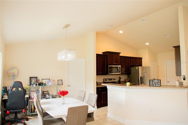 kitchen with appliances with stainless steel finishes, a breakfast bar, pendant lighting, dark brown cabinets, and high vaulted ceiling