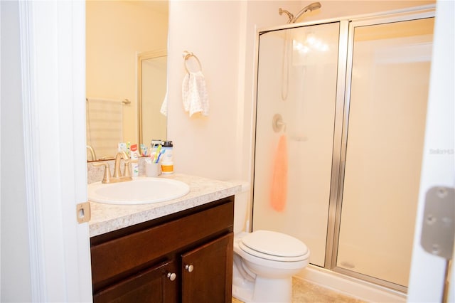 bathroom with toilet, vanity, and an enclosed shower