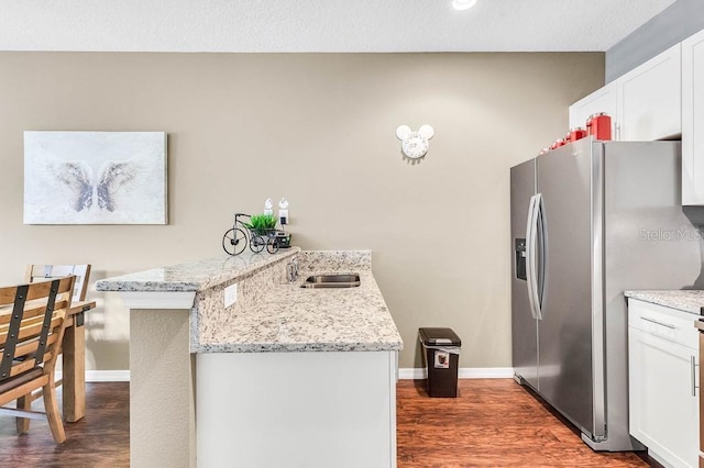 kitchen featuring white cabinetry, light stone countertops, stainless steel fridge with ice dispenser, and dark wood-type flooring