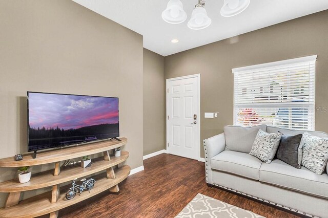 living room featuring dark wood-type flooring and a notable chandelier