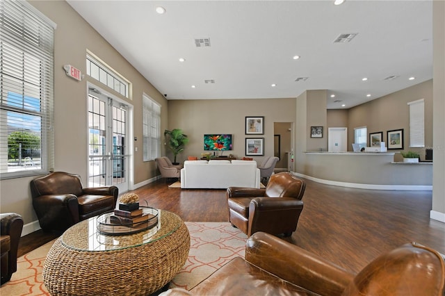 living area with baseboards, visible vents, wood finished floors, and recessed lighting