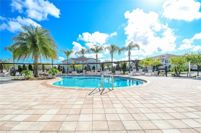 community pool with fence and a patio