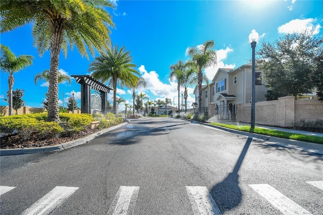 view of road featuring street lighting, a residential view, a gate, and curbs