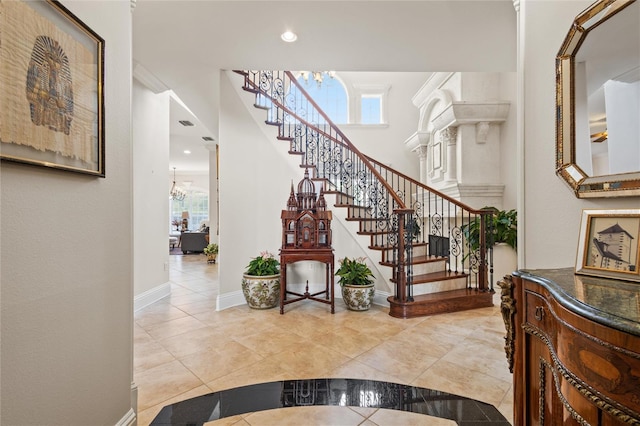 entryway with light tile patterned flooring and a notable chandelier