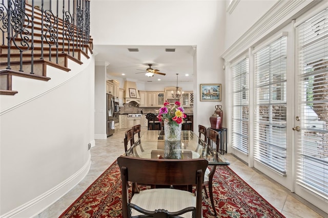 tiled dining space with ornamental molding, ceiling fan, and french doors