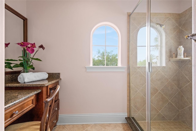 bathroom with tile patterned floors, a shower with door, and vanity